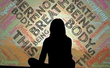 A silhouette of a person sitting cross-legged in front of a colorful background filled with motivational words like Breathe, Body, Being, Curiosity, Listening, and Observing.